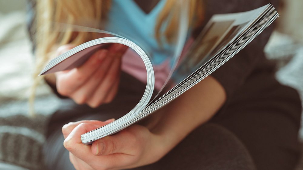 a photo of a woman's hands holding a book - a decorative elemet