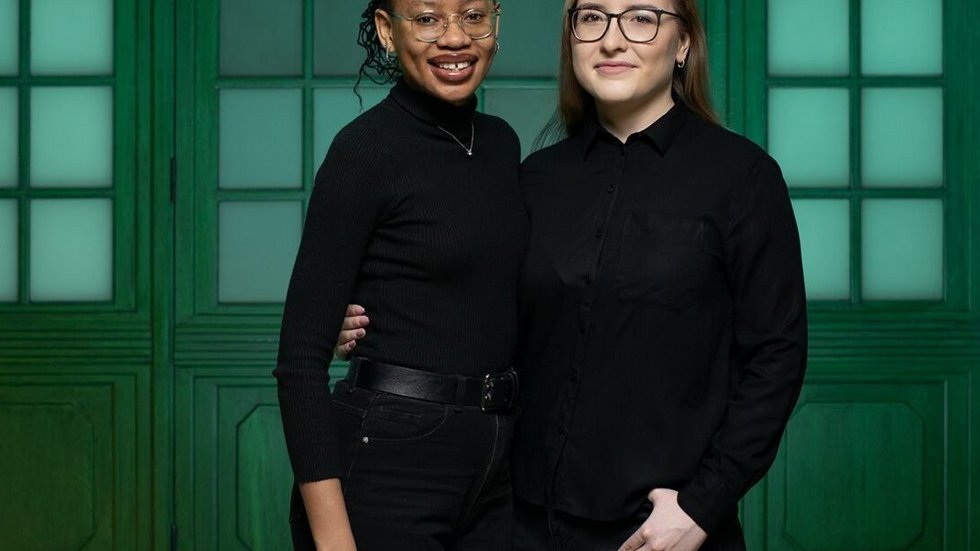 Two female students, i.e. UNIC Ambassadors at the University of Lodz, standing side by side on a green background
