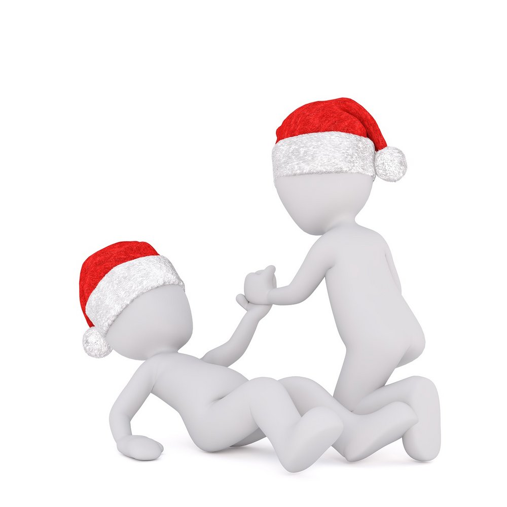 Dwa ludziki w czapkach Mikołaja. Jeden leży na podłodze, drugi pomaga mu wstać.