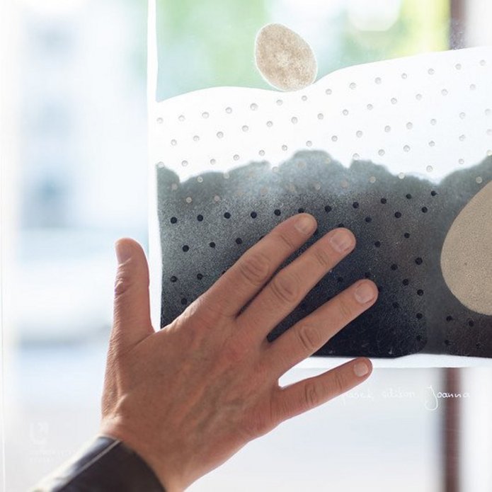 hand touching art work on glass