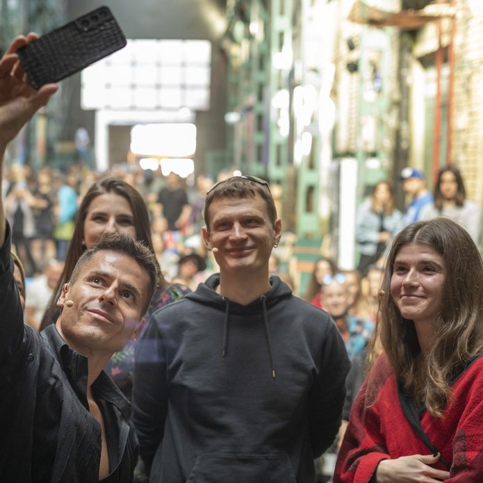 Grupa ludzi robiąca sobie wspólnie zdjęcie telefonem