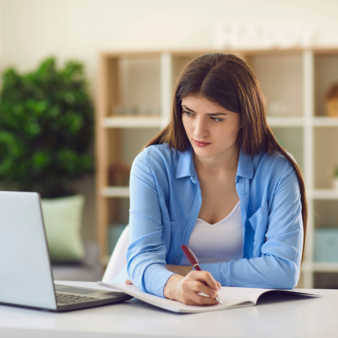 Dziewczyna robi notatki. Zdjęcie poglądowe.