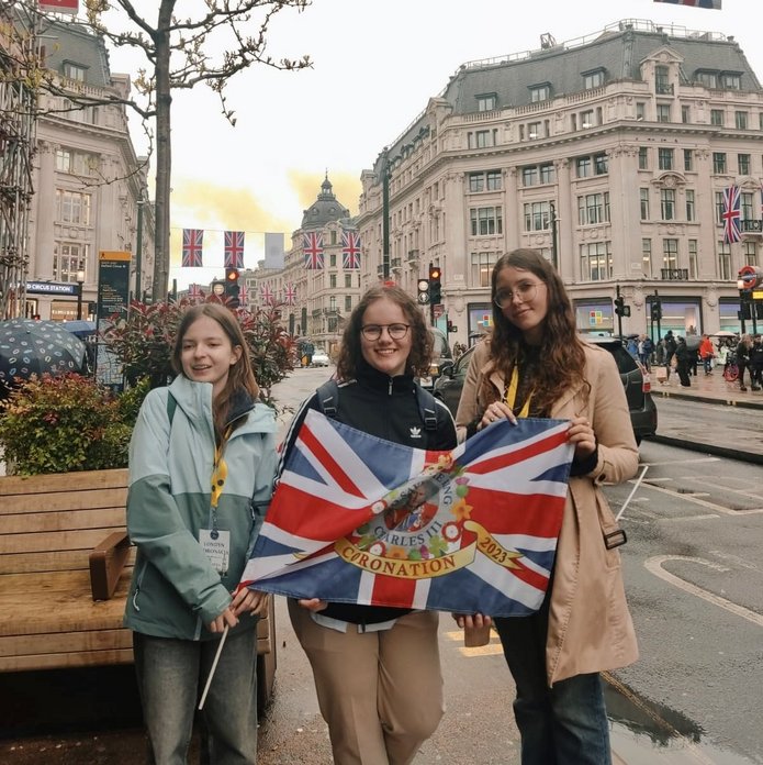 3 uczennice BISUL trzymające flagę brytyjską stojące na ulicach w Londynie