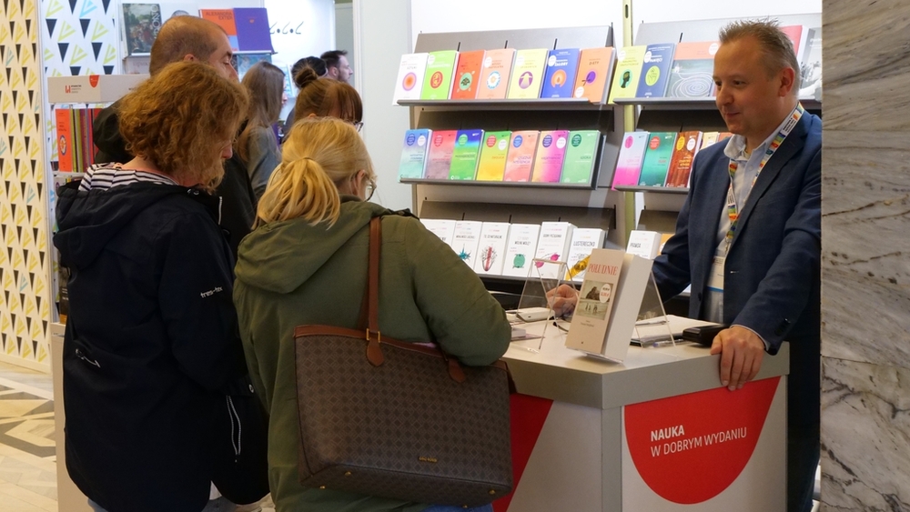 Ludzie stojący przy stoisku z książkami