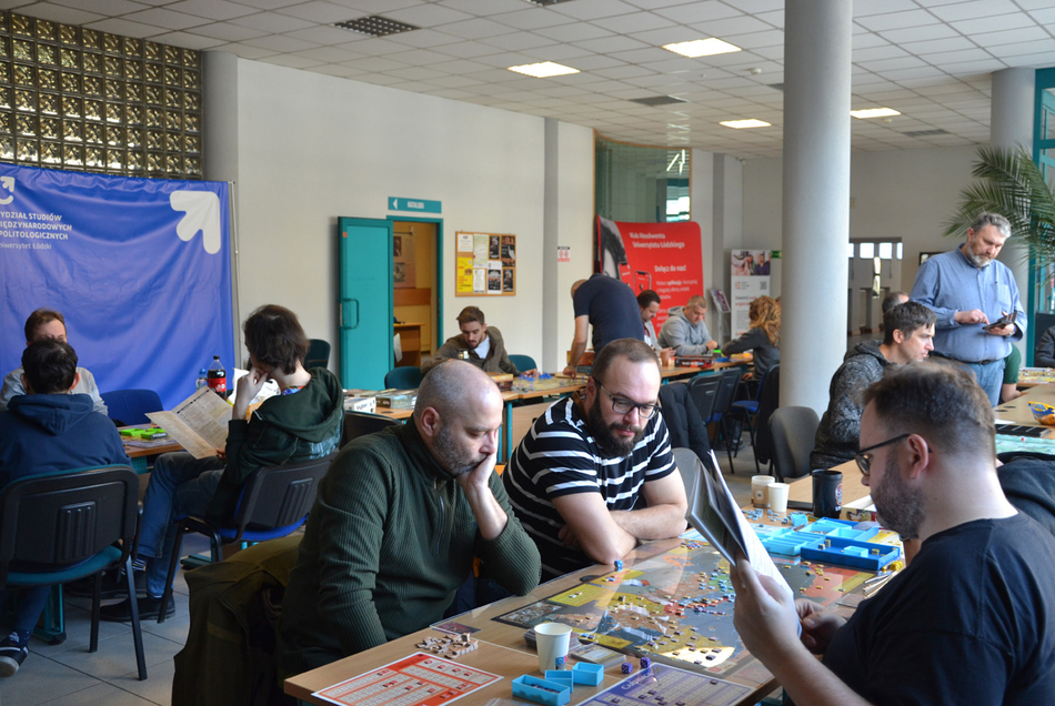 osoby uczestniczące w grze siedzące wokół stołu z grą osoby uczestniczące w grze siedzące wokół stołu z grą