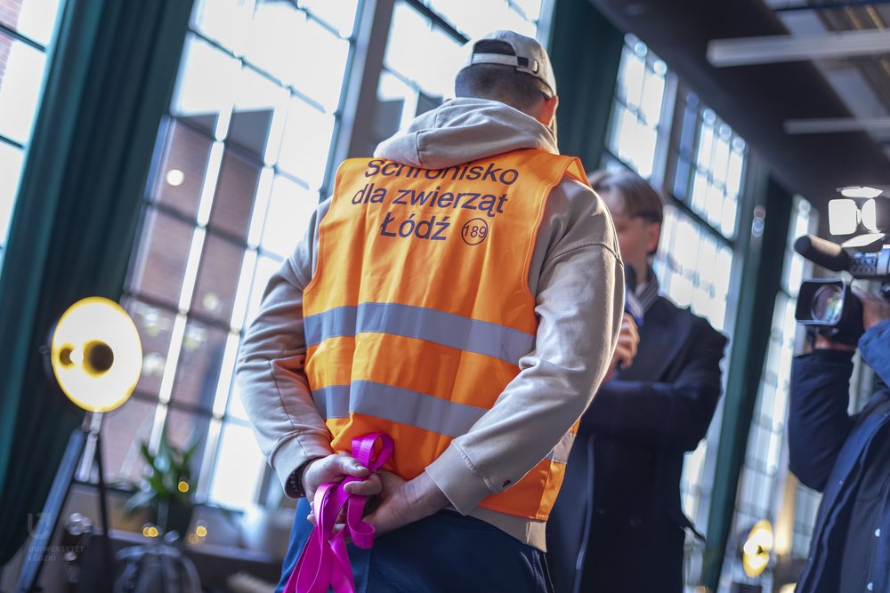 wolontariusz schroniska w pomarańczowej kamizelce