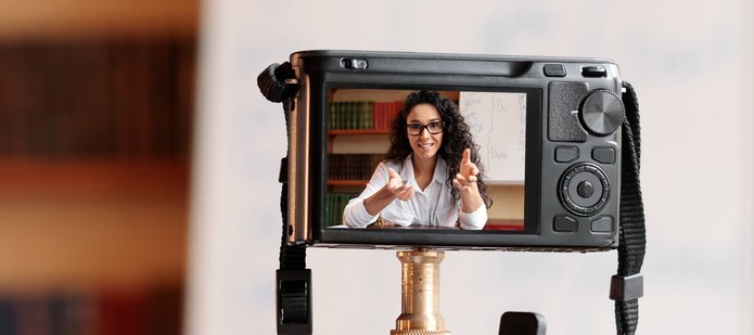 Twarz dziewczyny w obiektywie aparatu fotograficznego