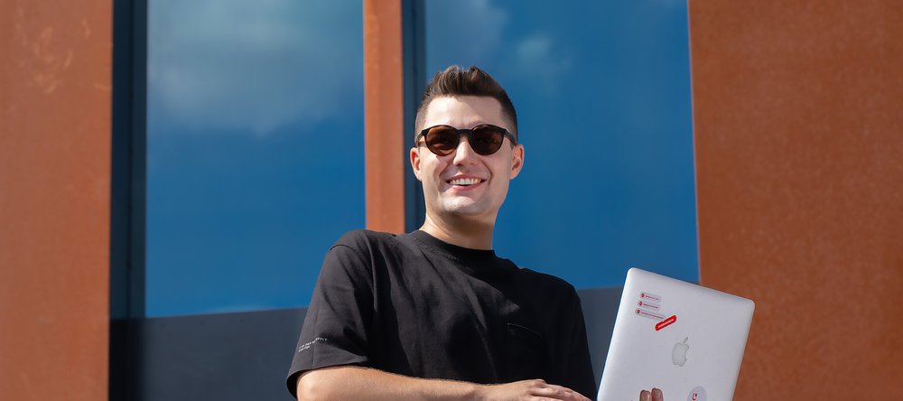 uśmiechnięty mężczyzna z laptopem