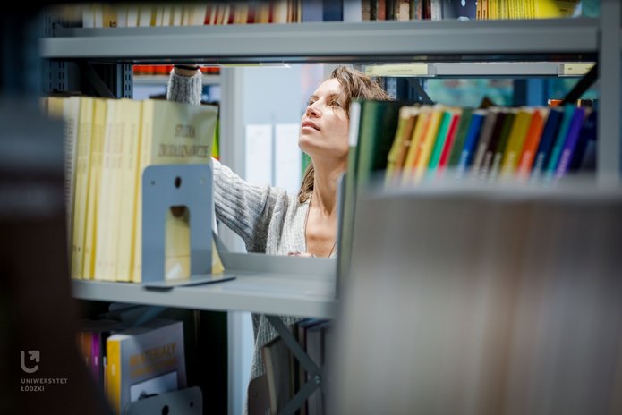 A girl between the bookshelves