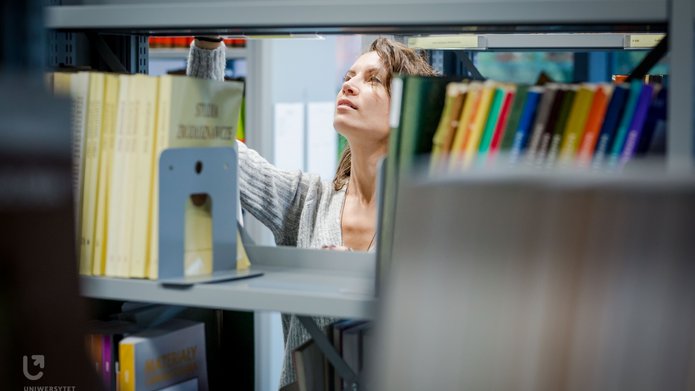 A girl between the bookshelves