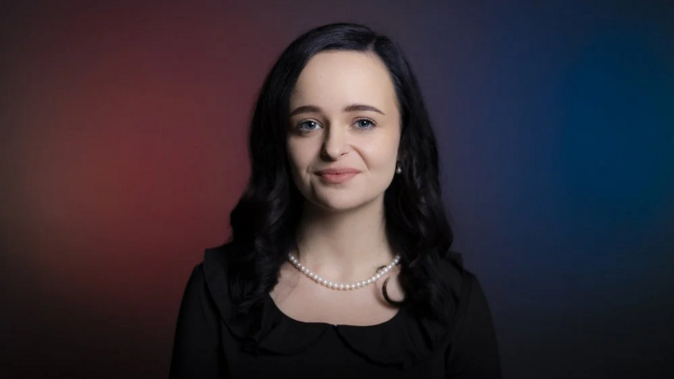 A UniLodz student smiles directly at the camera.