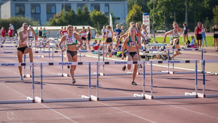 sportowcy skaczący przez płotki