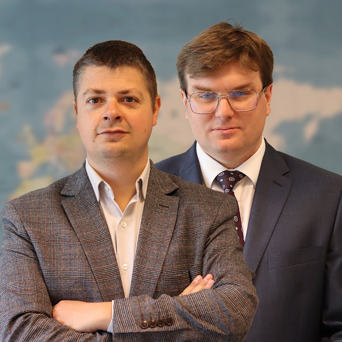 Dr Lachowski i dr Piątkowski na tle mapy świata.