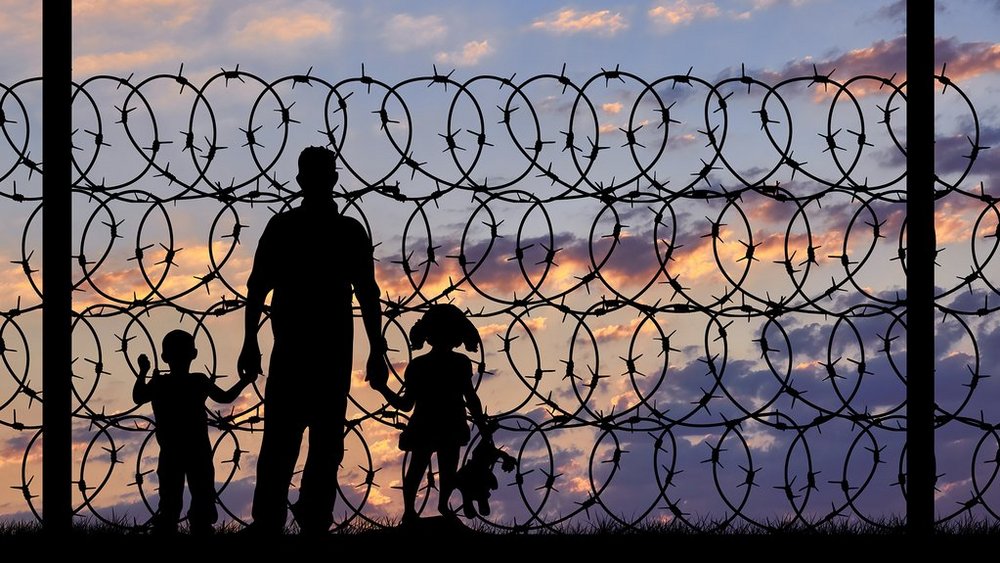 a decorative element: shadows of figures behind barbed wire