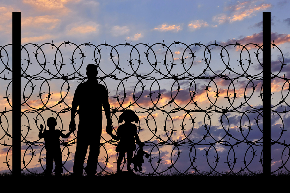 People against a backdrop of barbed wire