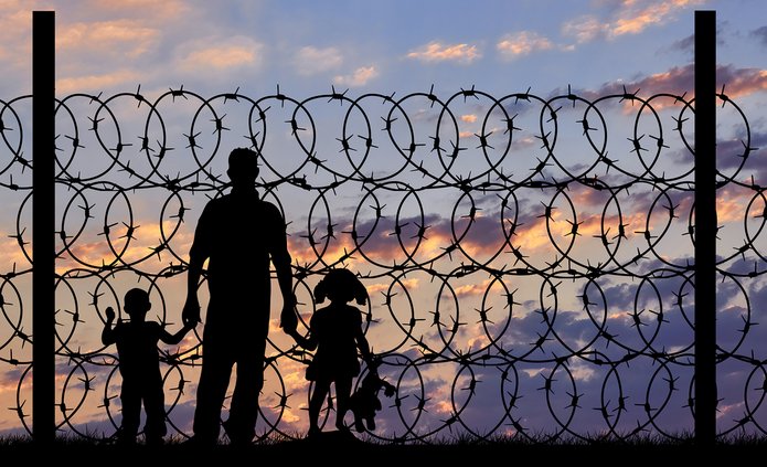 People against a backdrop of barbed wire