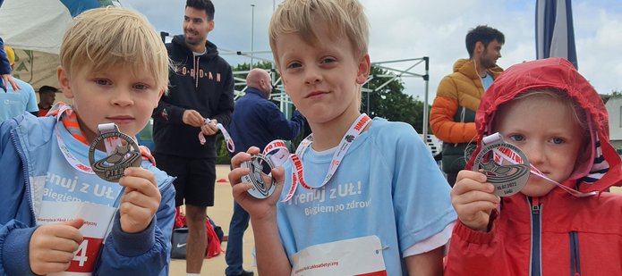 Trójka dzieci z medalami podczas pikniku lekkoatletycznego