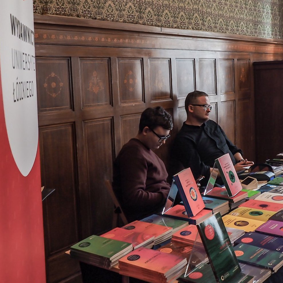 Organizatorzy konferencji za stołem z materiałami promocyjnymi