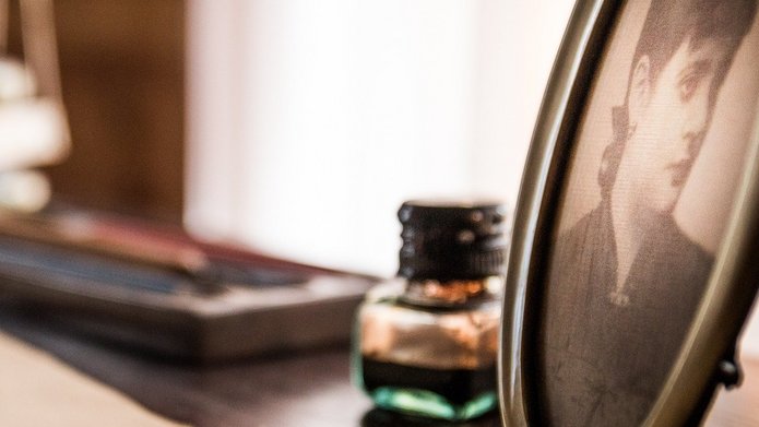 Letters, a photo of a woman and an ink bottle on a desk