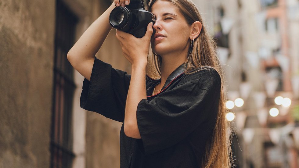A decorative element: a young woman taking photos in the city