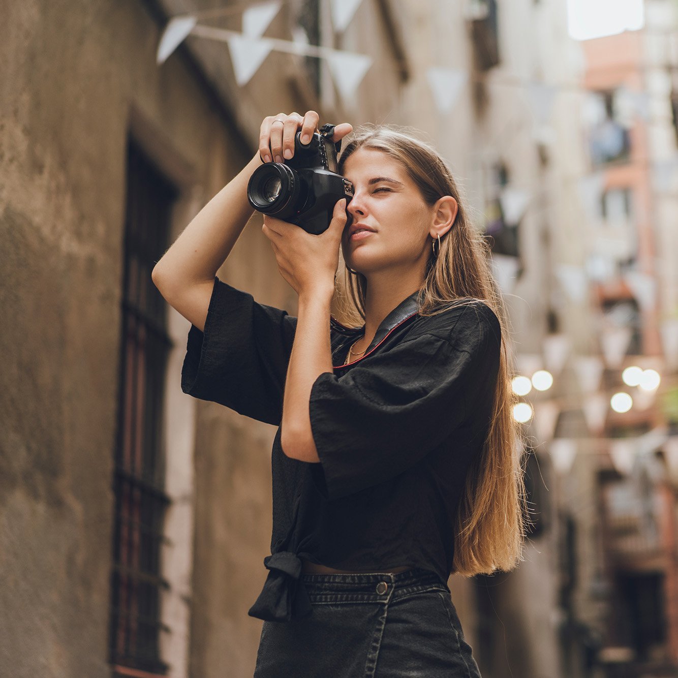 A decorative element: a young woman taking photos in the city