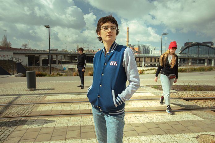 Troje studentów UŁ stojących na tle zabudowań Dworca Łódź Fabryczna