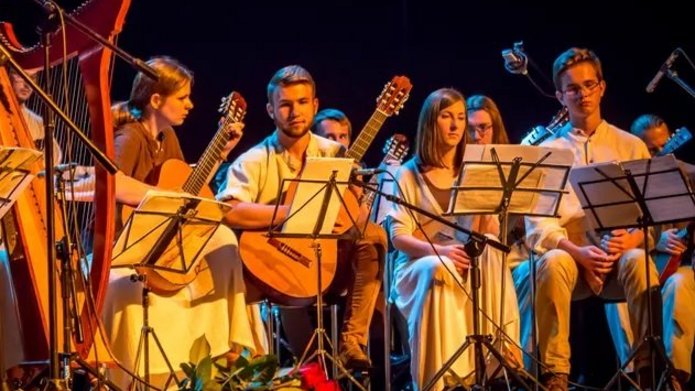 Members of the Academic Slavic Nations Music Band "Balalaikas" sitting on the stage with their instruments