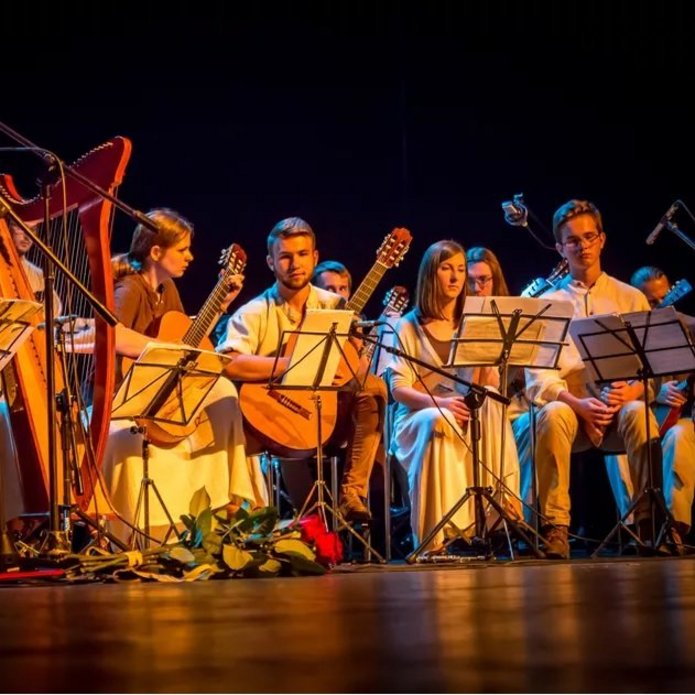 Członkowie Akademickiego Zespołu Muzyki Narodów Słowiańskich Bałałajki na scenie z instrumentami