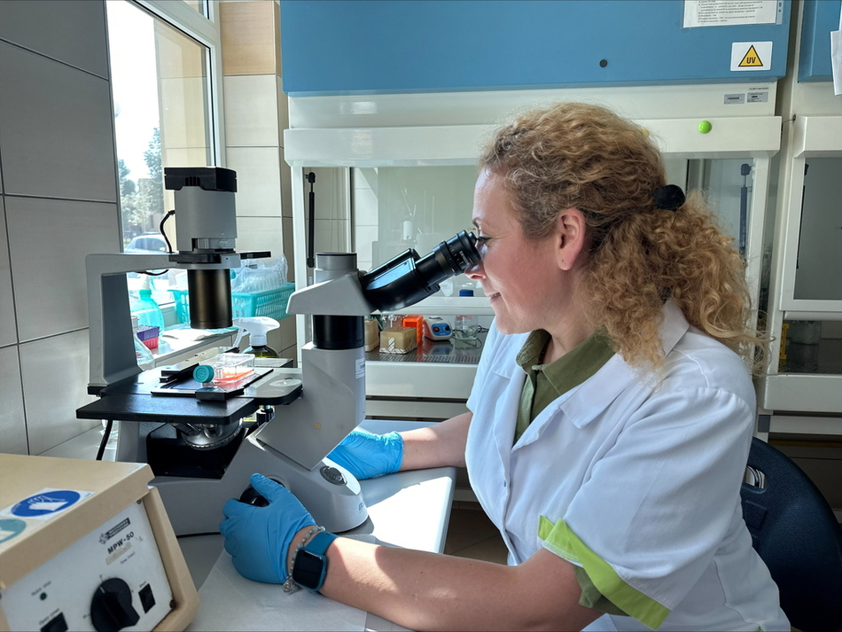  the scientist working at a microscope