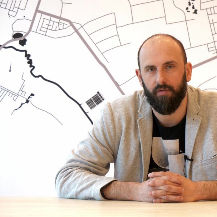 Mężczyzna siedzący przy stole - dr Piotr Szwed