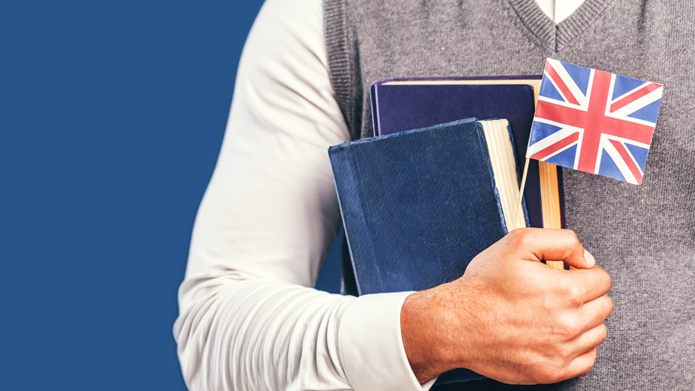 Osoba trzymająca książki i flagę Wielkiej Brytanii