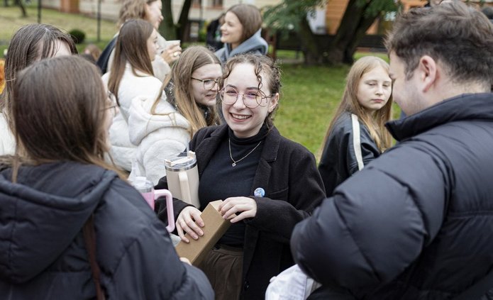 A colour photo of smiling students during a picnic at the UniLodz campus