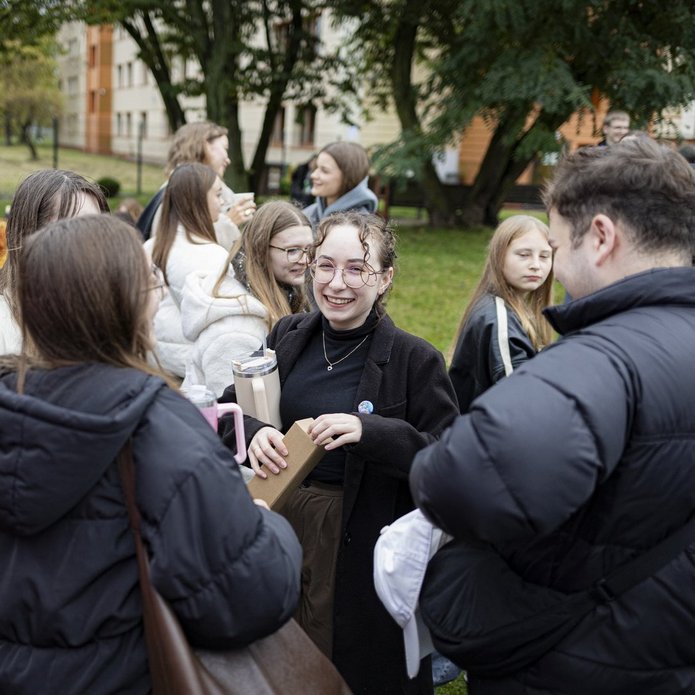 A colour photo of smiling students during a picnic at the UniLodz campus