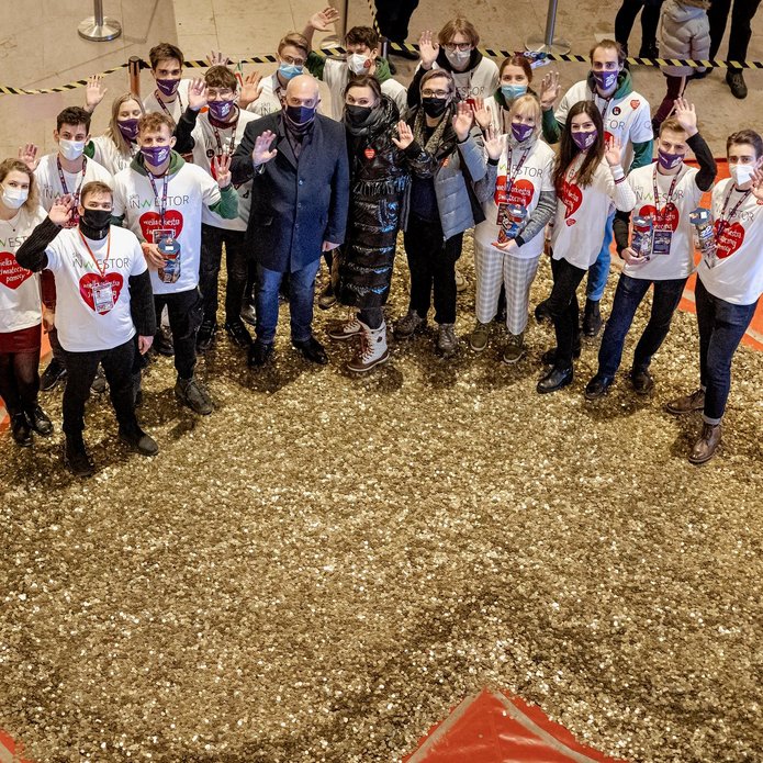 Students from the Student Science Club Inwestor and the University of Lodz authorities standing in front of a huge heart made of gold coins