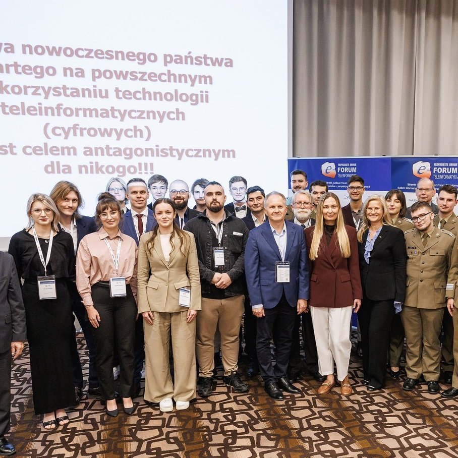 A group photo of the award winners, organizers, and participants of the 32nd ICT Forum. The participants are standing in several rows against a backdrop of screens displaying the Forum’s logos and the event’s slogan.