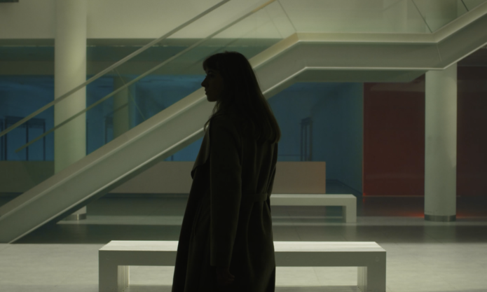 A girl standing inside a building, fragment from the video