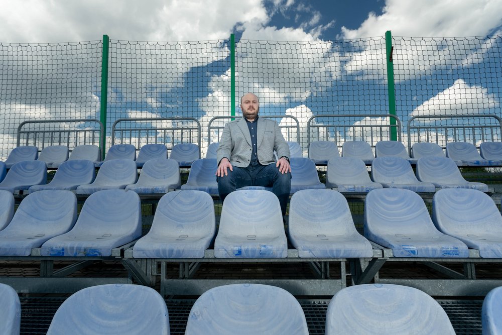 Prof. Michał Bijak siedzi na trybunach stadionu