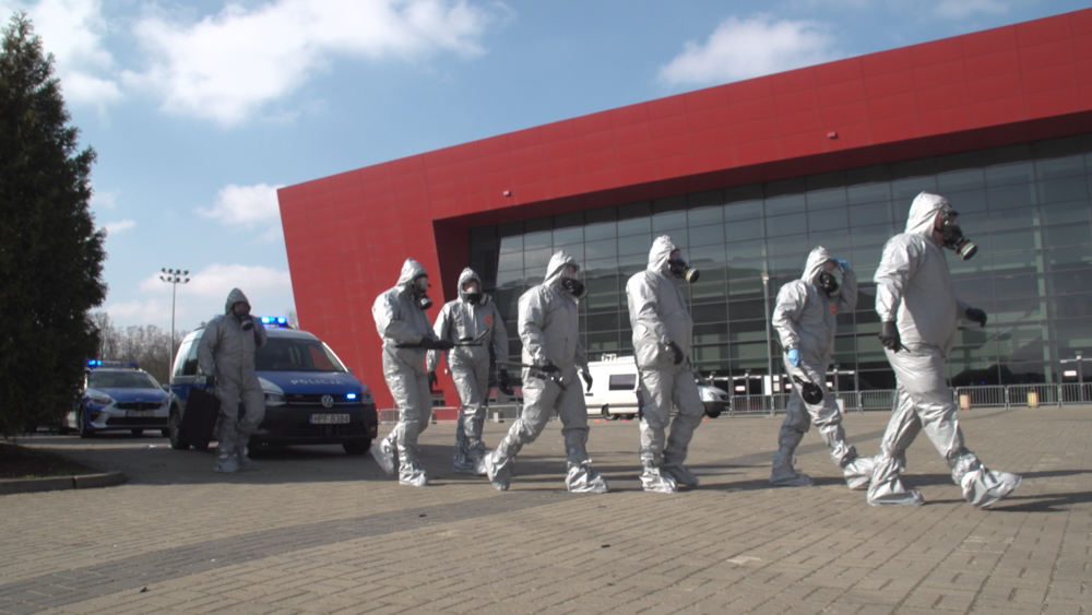 ludzie maszerujący w strojach zabezpieczających ciało