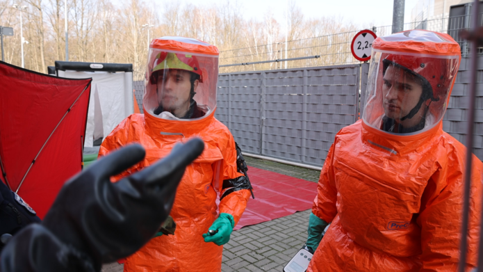 dwie osoby w strojach zabezpieczających ciało