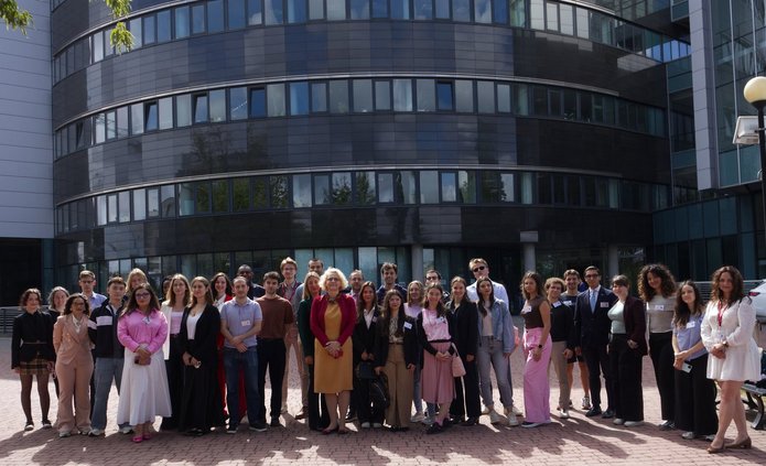 Studenci i wykładowcy pozują do zdjęcia przed gmachem wydziału