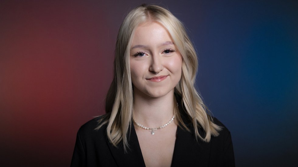 Uśmiechnięta blond dzieczyna na fioletowo granatowym tle