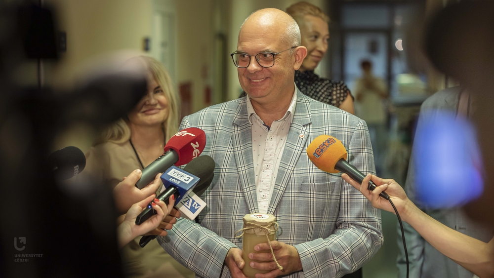 Prof. Robert Zakrzewski during a media briefing with a jar of honey in his hands