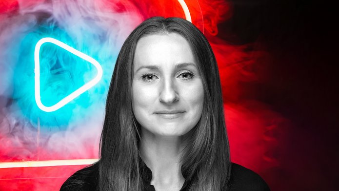 Dr Anna Barańska-Szmitko on the background of a neon sign resembling the YouTube logo