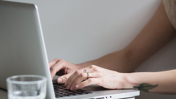 A girl typing on a laptop keyboard