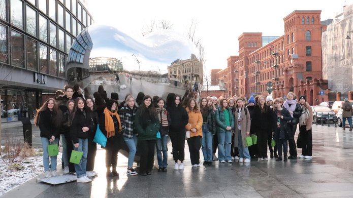A group of 30 high school students standing in front of the metal heart monument in Lodz