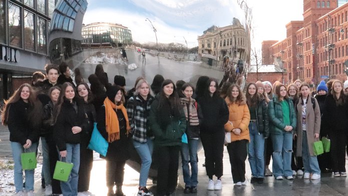 A group of high school students on the background of a silver heart in Lodz