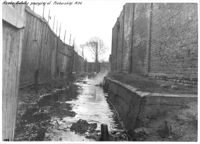 An archival photo of the Bałutka river flowing along the fences