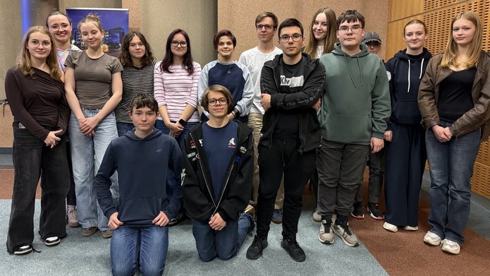 grupa młodych osób pozuje do zdjęcia w sali warsztatowej 