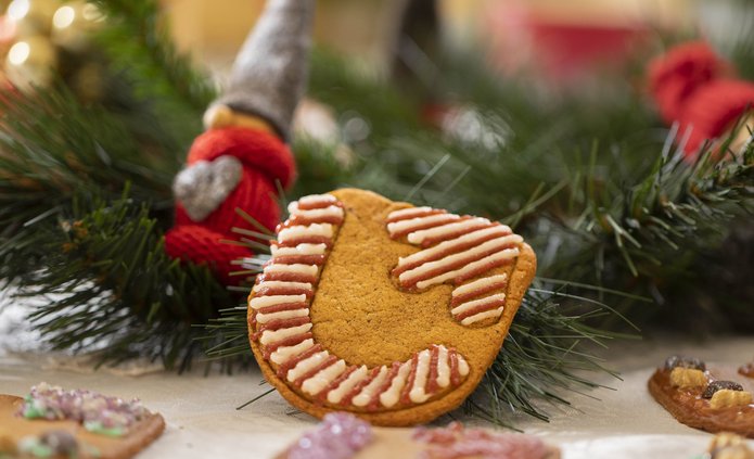 Christmas gingerbreads lying on the table among Christmas tree branches and baubles