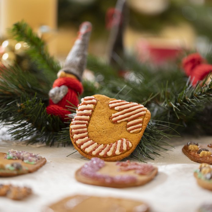 Christmas gingerbreads lying on the table among Christmas tree branches and baubles